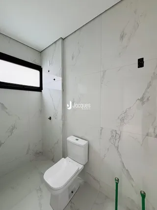 Foto interna de um banheiro com revestimento em mármore branco.