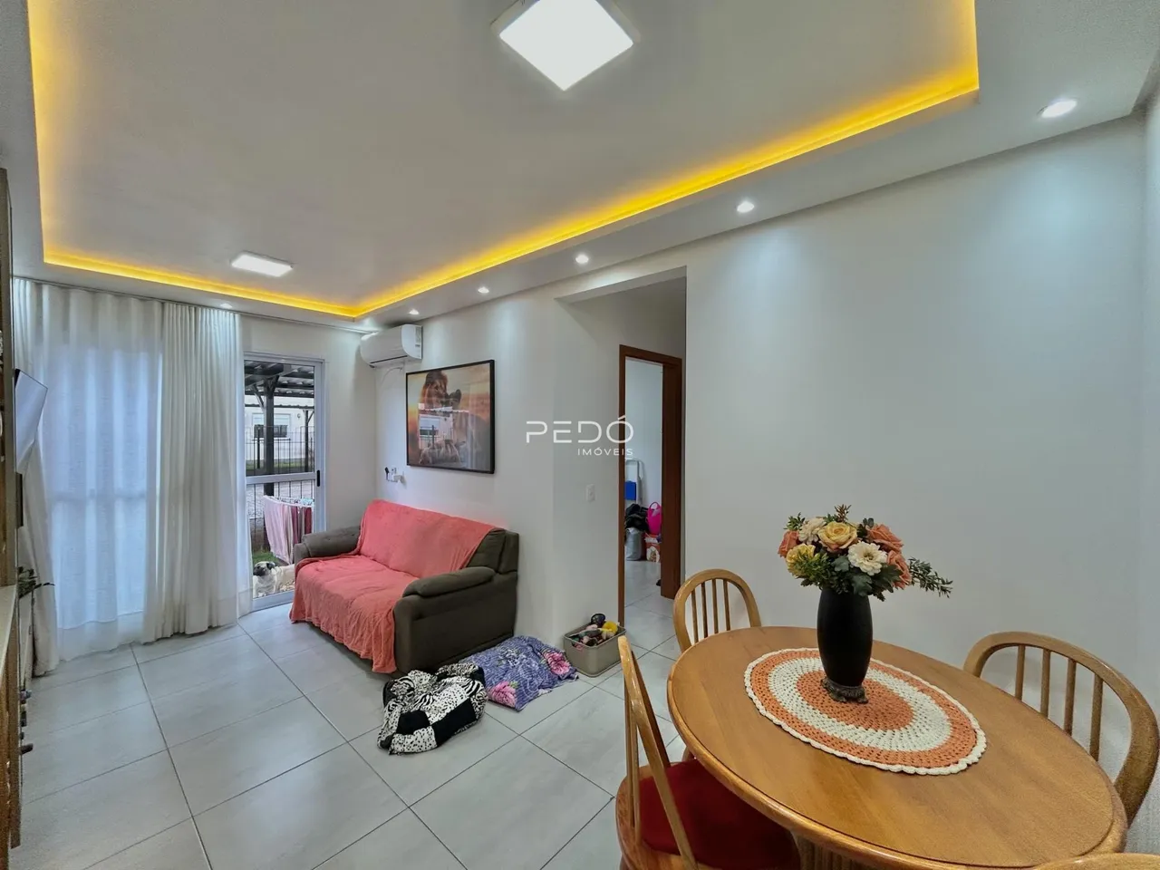Sala de estar e jantar com piso claro e paredes brancas em um imóvel no Brasil.