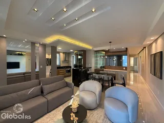Sala de estar moderna com sofá e poltronas em um ambiente de conceito aberto.