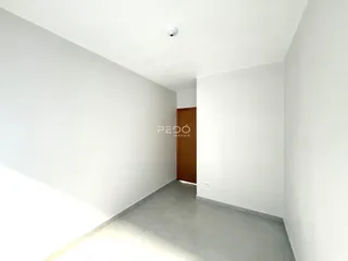Hall de entrada com paredes brancas e piso de cerâmica.