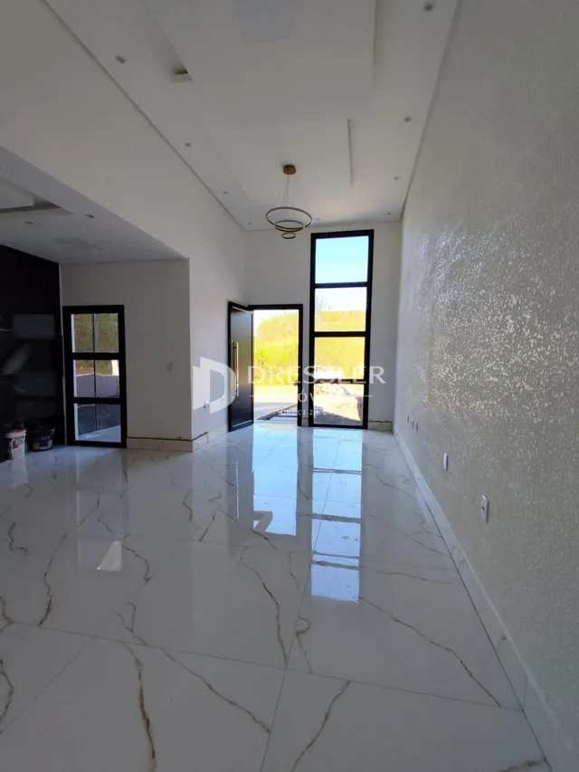 Área comum interna com piso de porcelanato branco refletivo.