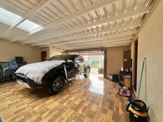 Foto do interior de um espaço com piso de cerâmica e uma caminhonete estacionada.