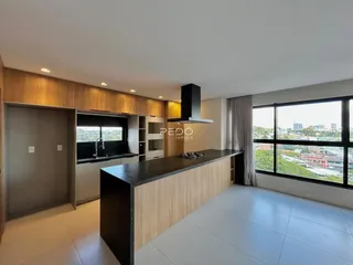 Vista da cozinha moderna com armários de madeira e grande janela.