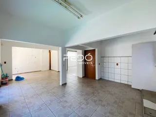 Interior de um corredor com piso de cerâmica e paredes brancas.