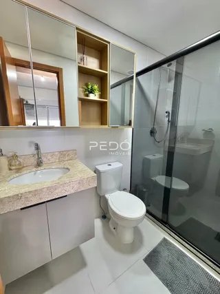 Foto de um banheiro com pia e box de vidro.