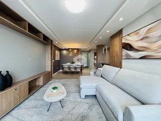 Sala de estar moderna com sofá branco e estantes de madeira.