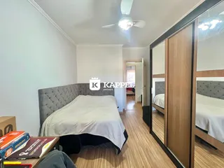Foto de um quarto com cama e piso de madeira clara.