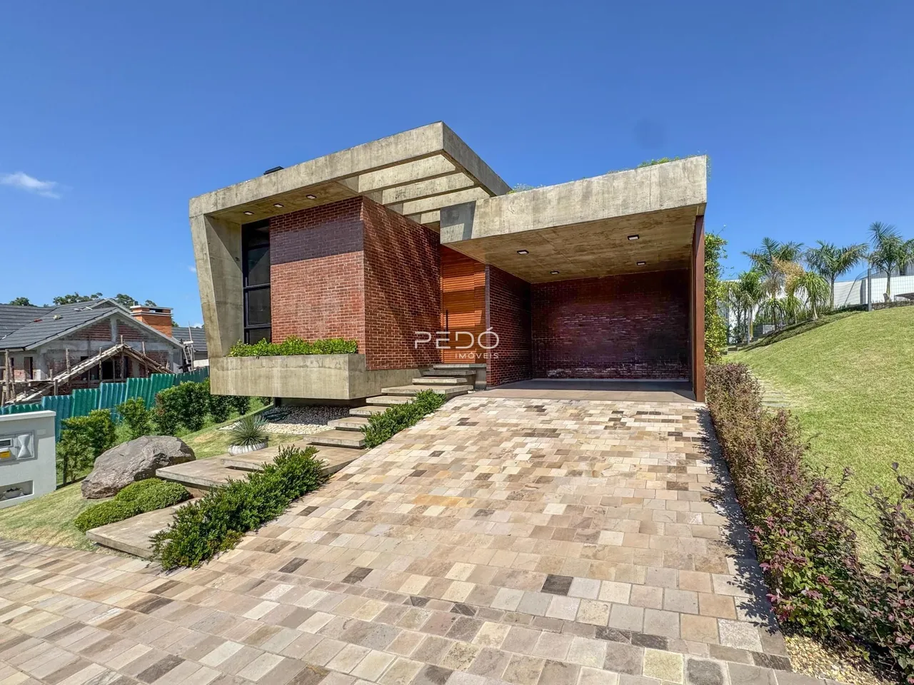 Fachada moderna de uma residência em Lajeado, Brasil, com área pavimentada.