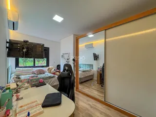 Quarto com janela e espelho refletindo outro ambiente.