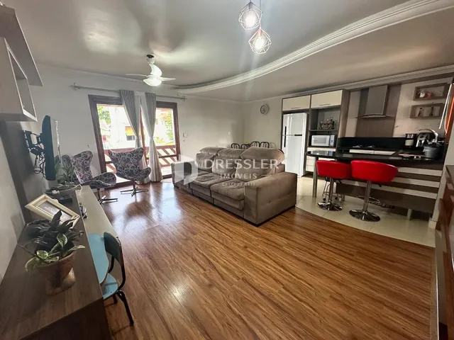 Sala de estar com piso de madeira e portas de vidro abrindo para o exterior.
