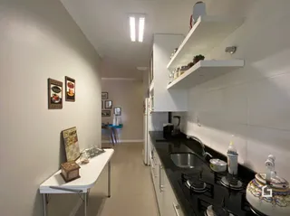 Corredor interno com prateleiras brancas e paredes claras.
