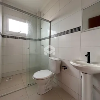 Foto interna de um banheiro com piso e paredes revestidos de cerâmica.