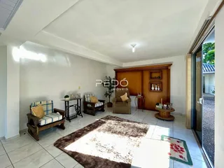 Sala de estar com móveis de madeira e piso cerâmico em Lajeado.