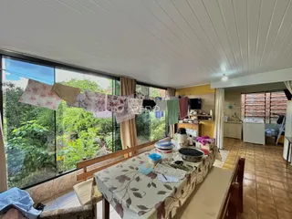 Vista da sala de jantar com vista para a vegetação externa.