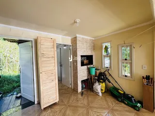 Interior da sala com piso de cerâmica e portas de madeira em uma residência.