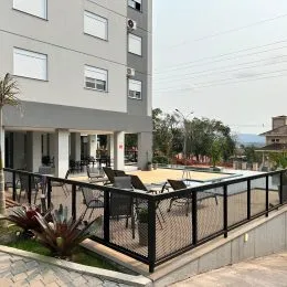 Vista externa de uma varanda com grade de metal preta em um imóvel em Lajeado.