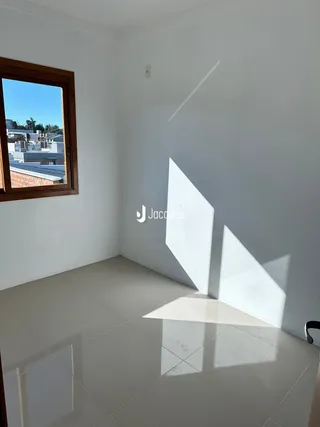 Interior de uma sala com parede branca e piso de cerâmica.