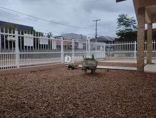 Uma cerca branca de madeira delimita a propriedade na frente.
