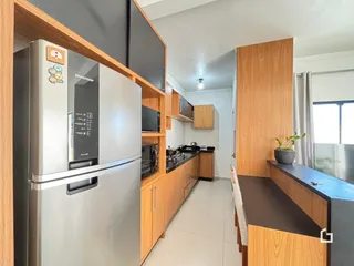 Vista interna de uma cozinha com armários de madeira e eletrodomésticos em Lajeado.