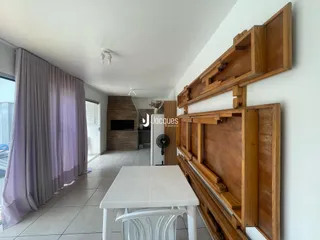 Interior de uma sala de estar com painel de madeira e janela grande.