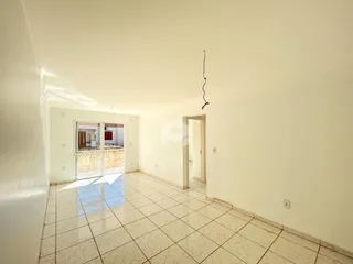 Ambiente interno com piso de cerâmica claro e paredes brancas.