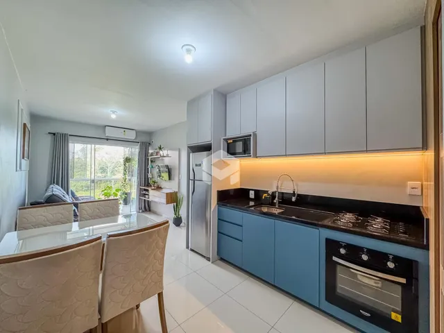 Vista interna de uma cozinha e sala de jantar com armários modernos.