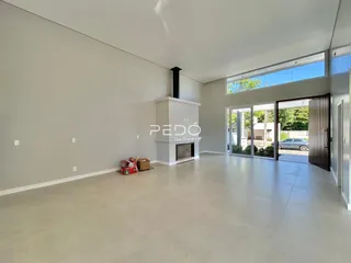 Ambiente interno moderno com grandes portas de vidro que dão acesso ao exterior.