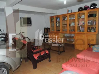 Foto de uma sala com móveis de madeira e piso de cerâmica.