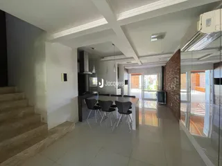 Interior de uma sala de estar com piso de cerâmica e portas de vidro.