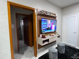 Sala de estar com televisão e móveis modernos em um apartamento.