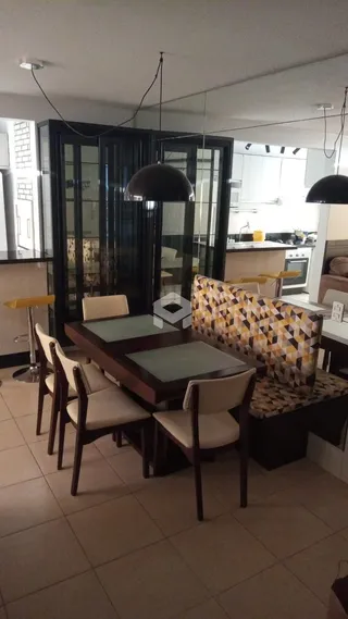 Uma sala de jantar com mesa de madeira e cadeiras.