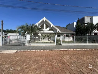 Fachada de uma casa em Lajeado, Brasil, com cerca e paisagismo.