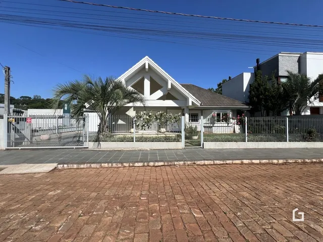 Fachada de uma casa em Lajeado, Brasil, com cerca e paisagismo.