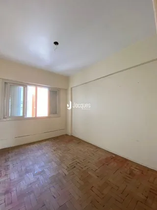 Um cômodo com paredes claras e piso de madeira é visível na foto.
