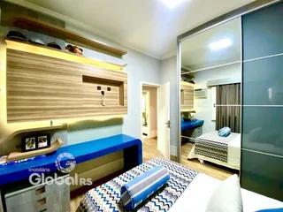 Quarto com cabeceira de madeira e espelho em um apartamento em Lajeado.