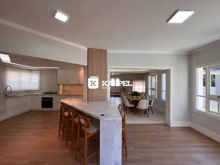 Esta foto exibe uma área de estar e cozinha integrada com piso de madeira.