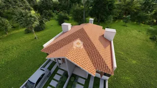 Fachada de uma residência com telhado de telhas de barro e jardim verde em Lajeado.