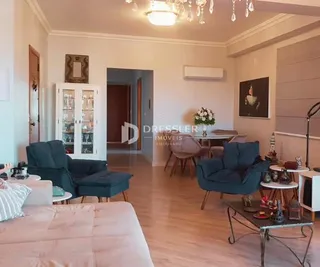 Sala de estar com piso de madeira clara e paredes claras.