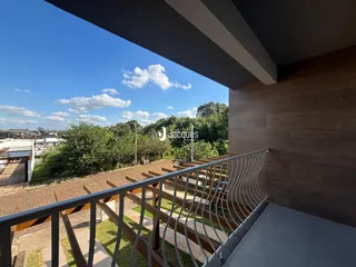 Vista da propriedade com paisagem verde e céu azul.