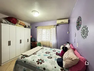 Quarto com armários brancos e cama decorada em Lajeado.