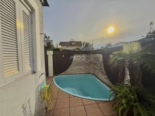 Foto externa de uma piscina e área de lazer em uma residência no Brasil.