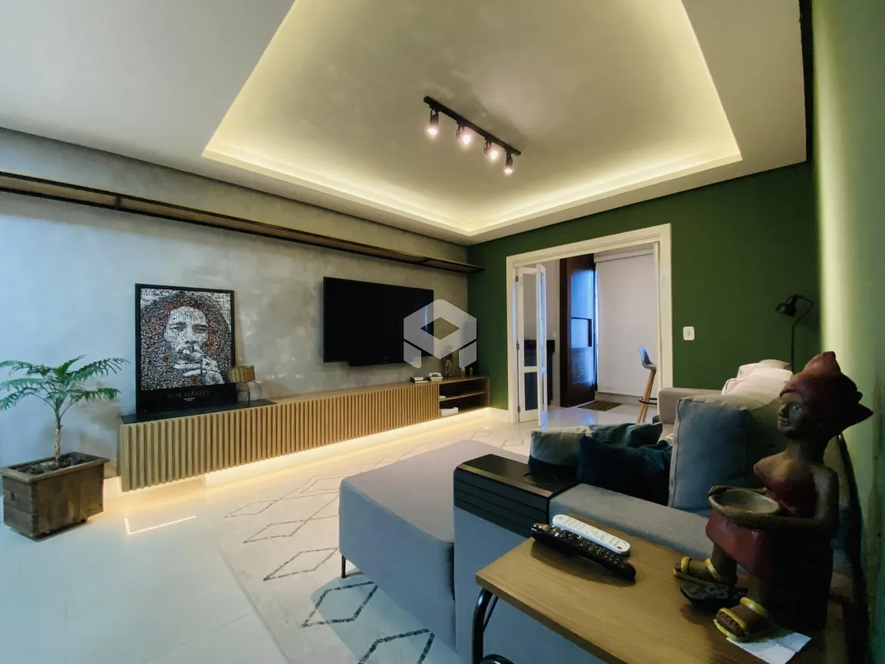 Sala de estar moderna com painel de madeira e televisão.