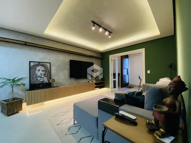 Sala de estar moderna com painel de madeira e televisão.