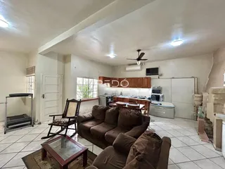 Sala de estar com sofá e cozinha em imóvel no Brasil.