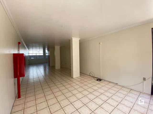 Corredor interno com piso de cerâmica claro.