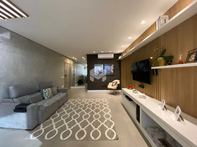 Sala de estar moderna com sofá e piso claro em um apartamento no Brasil.