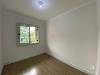 Ambiente interno com piso de madeira e janela.