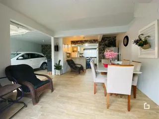 Ambiente interno de sala de jantar com piso de cerâmica clara e móveis de vime.