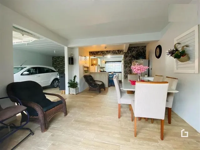 Ambiente interno de sala de jantar com piso de cerâmica clara e móveis de vime.