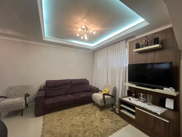 Sala de estar com sofá marrom e iluminação de teto.